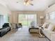 Living room with gray vinyl plank flooring, sliding glass doors, and a comfortable seating area at 7471 Crooked Lake Cir, Orlando, FL 32818