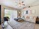 Living room with beige sectional sofa, a ceiling fan, and sliding glass doors at 7471 Crooked Lake Cir, Orlando, FL 32818