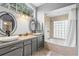 Bathroom with double vanity, soaking tub, and glass block window at 12512 Tillingham Sw Ct, Orlando, FL 32837