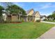 Home's exterior features a large front yard and mature trees at 12512 Tillingham Sw Ct, Orlando, FL 32837