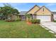 House exterior showcasing a well-maintained lawn and landscaping at 12512 Tillingham Sw Ct, Orlando, FL 32837