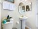 Small bathroom with pedestal sink, toilet and an oval mirror at 1522 Moon Valley Dr, Davenport, FL 33896