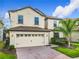 Two-story house with beige exterior, a three-car garage, and a landscaped front yard at 1522 Moon Valley Dr, Davenport, FL 33896