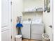 Laundry room with washer, dryer, and shelving at 1522 Moon Valley Dr, Davenport, FL 33896