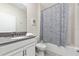 Clean bathroom with a shower/tub combo, gray vanity, and patterned shower curtain at 2770 Bookmark Dr, Kissimmee, FL 34746