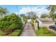 Gated entrance with brick driveway, lush landscaping, and lake view at 3314 Trentwood Blvd, Belle Isle, FL 32812