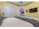 Spacious bedroom with a queen bed, yellow walls and a flat-screen TV at 36 Allenwood Look, Ormond Beach, FL 32174