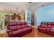 Relaxing Gathering room with a view of the kitchen and comfortable red leather couches at 36 Allenwood Look, Ormond Beach, FL 32174