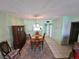 Dining room with a wooden table and chairs, and a view into the kitchen at 721 S Beach St # 217A, Daytona Beach, FL 32114