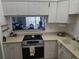 Kitchen with white cabinets, stainless steel appliances, and view to living room at 721 S Beach St # 217A, Daytona Beach, FL 32114