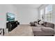 Bright living room with L-shaped sofa and large TV at 1174 Seaside Mist Trl, Kissimmee, FL 34747