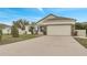 Exterior view of a single-story house with a two-car garage and landscaped yard at 121 Big Black Dr, Kissimmee, FL 34759