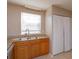 Kitchen features wood cabinets, double sink, and laundry closet at 404 Banyon Tree Cir # 200, Maitland, FL 32751