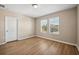 Well-lit bedroom with wood-look floors and two windows at 4803 Terrasonesta Dr, Davenport, FL 33837