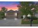 Two-story house with beige siding, three car garage, and landscaped yard at 5307 Cortland Dr, Davenport, FL 33837