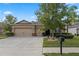 Beige house with a three car garage, manicured lawn, and mature trees at 5307 Cortland Dr, Davenport, FL 33837