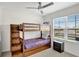 Bedroom with a bunk bed, window with blinds, and a small nightstand at 1117 Star Ruby Ln, Winter Haven, FL 33880
