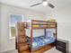 Bedroom with a bunk bed, ceiling fan, and window with blinds at 1117 Star Ruby Ln, Winter Haven, FL 33880