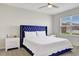 Bedroom with blue velvet headboard and white bedding at 1117 Star Ruby Ln, Winter Haven, FL 33880