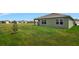 Green house exterior with a covered patio and large backyard at 1117 Star Ruby Ln, Winter Haven, FL 33880