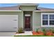 House entrance with a dark brown door and white garage door at 1117 Star Ruby Ln, Winter Haven, FL 33880
