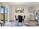 Bright dining room with glass table and four chairs, plus access to a sliding glass door leading to the backyard at 1117 Star Ruby Ln, Winter Haven, FL 33880