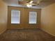 Spacious carpeted bedroom with two large windows and ceiling fan at 13910 Dove Wing Ct, Orlando, FL 32828