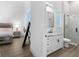 White bathroom with marble vanity and shower, adjacent to bedroom at 16848 Vinci Way, Montverde, FL 34756