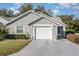 Cute one-story house with a white garage door and well-manicured lawn at 2402 Sw 20Th Ter, Ocala, FL 34471