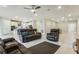 Open living room with leather reclining furniture and a view into the kitchen at 2695 Hilltop Loop, Apopka, FL 32712