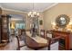 Formal dining room with hardwood floors, chandelier, and views to living areas at 1221 Glendora N Rd, Kissimmee, FL 34759