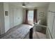 Bright bedroom featuring a crib, rocking chair, and ample closet space at 15121 Pigeon Plum Ln, Winter Garden, FL 34787