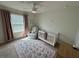 Charming bedroom with a crib, rocking chair, and neutral decor at 15121 Pigeon Plum Ln, Winter Garden, FL 34787