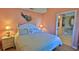 King-size bed, light peach walls, and coastal decor in the main bedroom with ensuite bathroom at 5300 S Atlantic Ave # 2-502, New Smyrna Beach, FL 32169