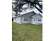 Side view of a charming light gray house with green lawn at 603 Maggie Cir, Winter Haven, FL 33880