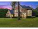 Two story house with stone accents, welcoming front porch and landscaping at dusk at 8407 River Branch Pl, Sanford, FL 32771