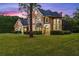 Two story house with stone accents, welcoming front porch and landscaping at dusk at 8407 River Branch Pl, Sanford, FL 32771