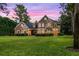 Two-story house with stone accents and a welcoming front porch at dusk at 8407 River Branch Pl, Sanford, FL 32771