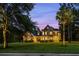 Two story house with stone accents, palm trees, and welcoming front porch at dusk at 8407 River Branch Pl, Sanford, FL 32771