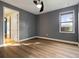 Bright bedroom with wood-look floors, ceiling fan, and an ensuite bathroom at 8681 Crested Eagle Pl, Sanford, FL 32771