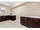 Laundry room with dark brown cabinets, tile floor and a utility sink at 8681 Crested Eagle Pl, Sanford, FL 32771