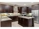 Spacious kitchen featuring granite countertops, stainless steel appliances, and dark wood cabinetry at 8681 Crested Eagle Pl, Sanford, FL 32771