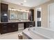 Bathroom with double vanity, large mirror and a separate tub and shower at 8681 Crested Eagle Pl, Sanford, FL 32771