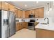 Modern kitchen with stainless steel appliances and light wood cabinets at 10274 Hadley St, Orlando, FL 32829