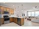 Open kitchen boasts stainless steel appliances and light wood cabinets at 10274 Hadley St, Orlando, FL 32829