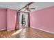 Bedroom with pink walls and wood-look floors at 1836 N Crystal Lake Dr # 31, Lakeland, FL 33801
