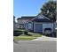 Gray house with attached garage and driveway, nicely landscaped yard at 2314 Carriage Run Rd, Kissimmee, FL 34741