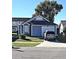 Gray house with a two-car garage and a landscaped lawn at 2314 Carriage Run Rd, Kissimmee, FL 34741