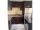 Galley kitchen with dark cabinets and granite counters at 2802 N Powers Dr # 18, Orlando, FL 32818