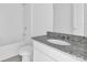 Clean bathroom with tub, toilet, and granite vanity at 416 Mckenna Dr, Winter Haven, FL 33881